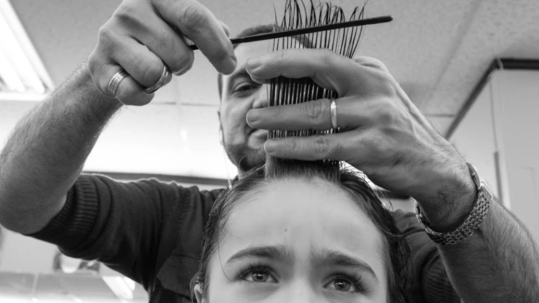 A barber styling a client's hair at Majidian Barbers in Kitsilano, Vancouver